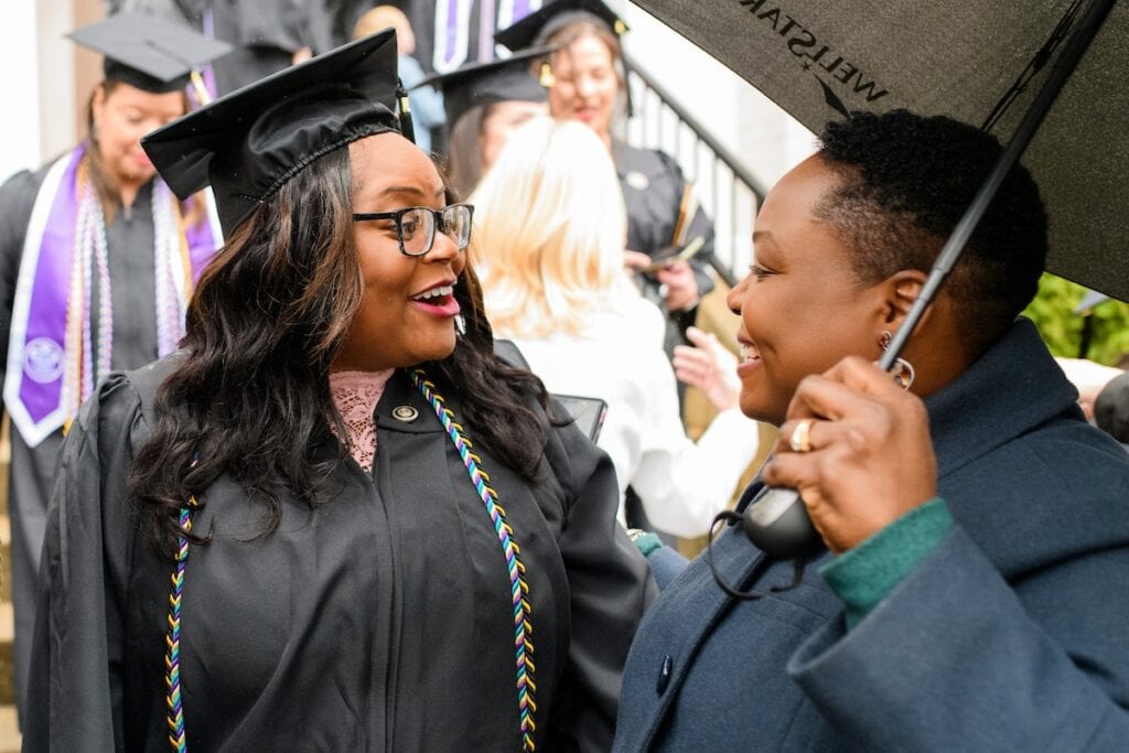 student meets with parent after ceremony