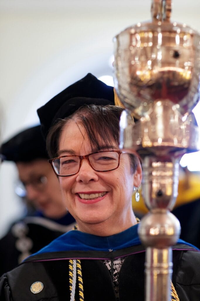 professor holding staff that is used for graduation
