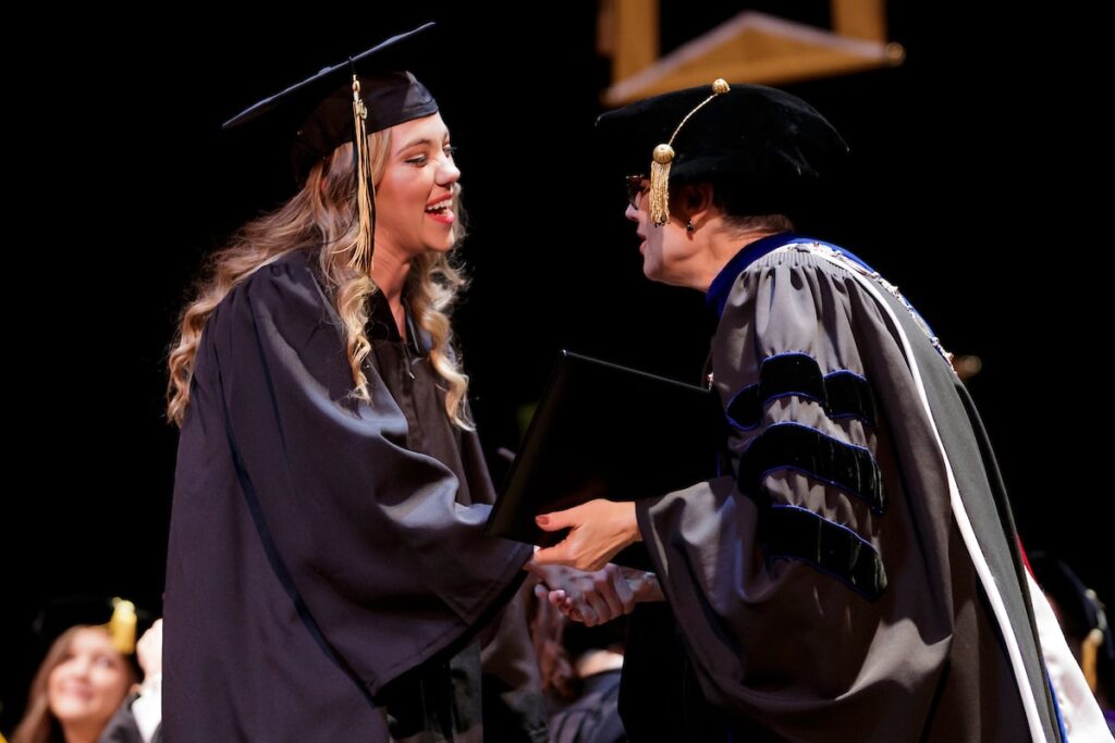 president shaking hands with student