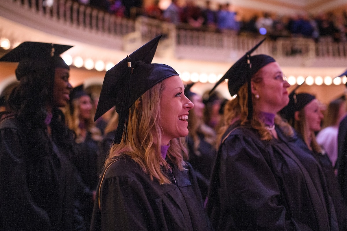 Stephanie Lynn Burns laughs from her seat during the Brenau University Graduate Commencement ceremony on Friday