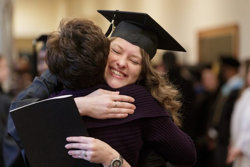 Shelby Elizabeth-Kaye McClain gets a hug from Brenau Chief of Staff Jody Wall during the Brenau University Graduate Commencement ceremony on Friday, Dec. 14, 2018 in Gainesville, Ga. (AJ Reynolds/Brenau University)