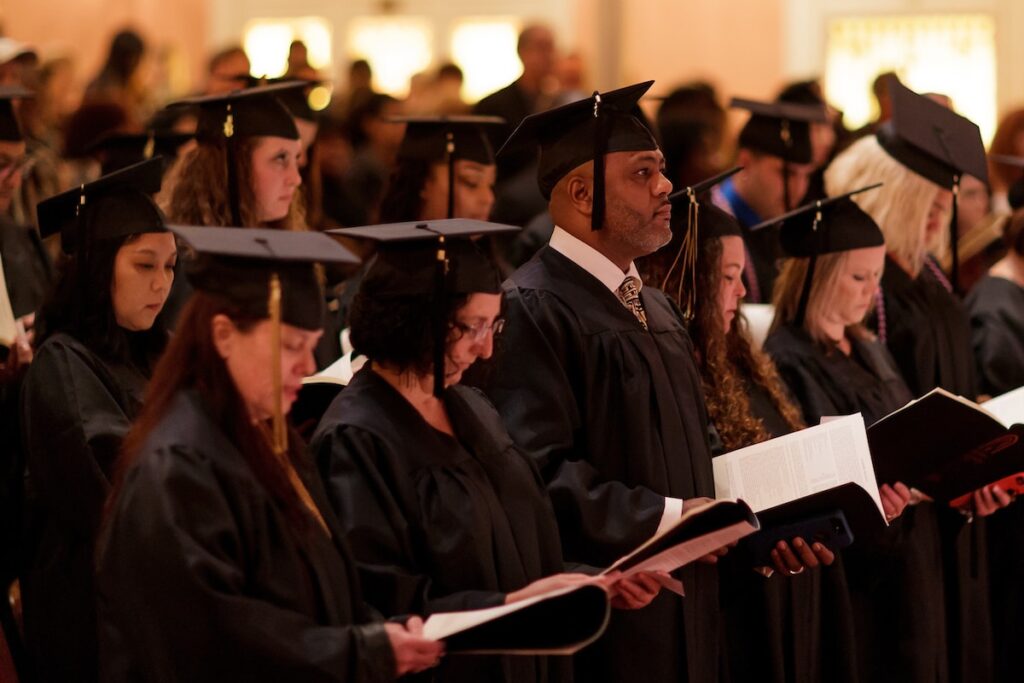 Graduates stand during the singing of O God Our Help in Ages Past during the Brenau University Undergraduate Commencement ceremony on Friday, Dec. 14, 2018 in Gainesville, Ga. (AJ Reynolds/Brenau University)
