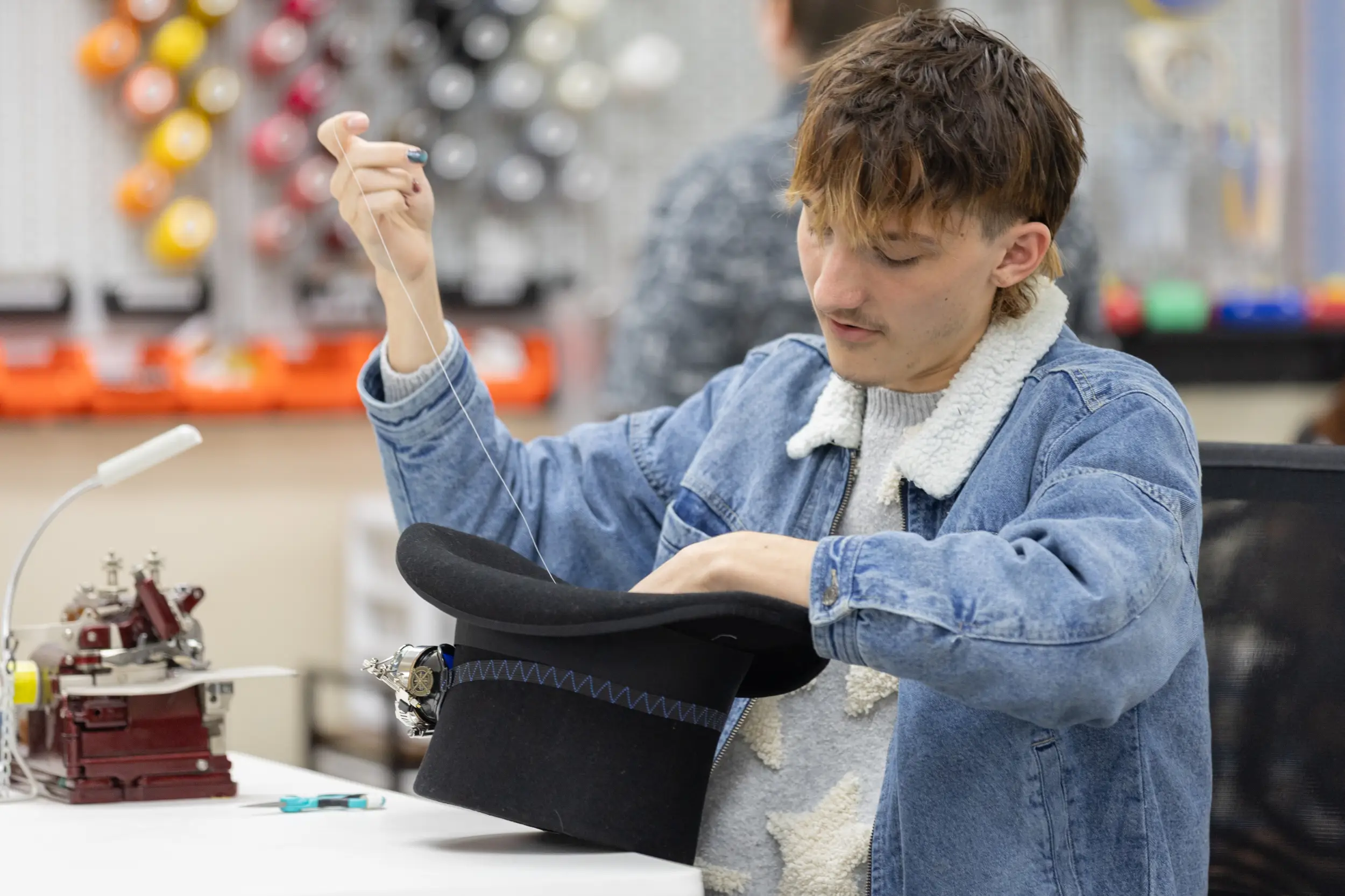 Student sewing a hat