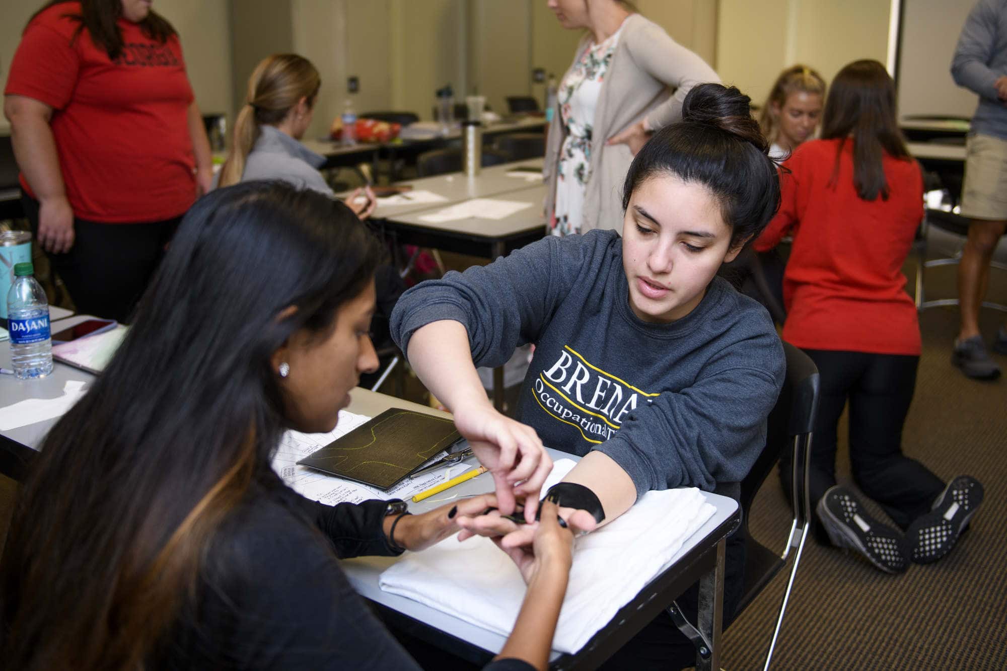 Occupational therapy students practice hand splints in class