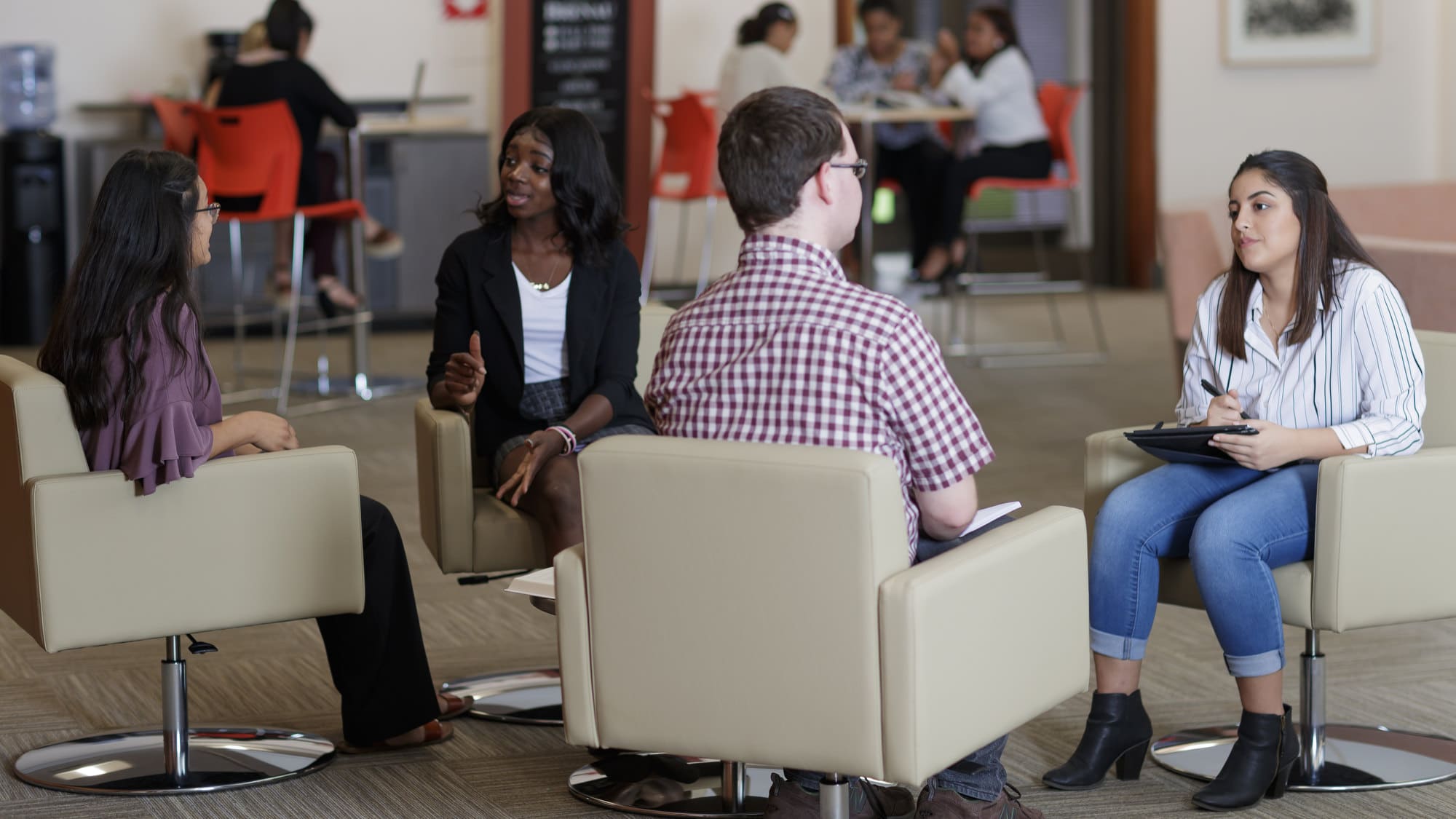 Business students study inside the lobby of the Jacobs Building