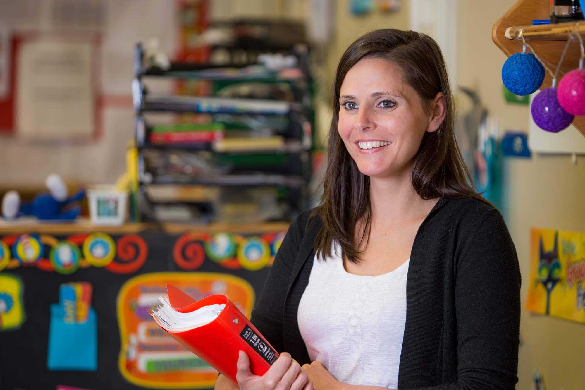 A teacher poses for a photo inside her classroom