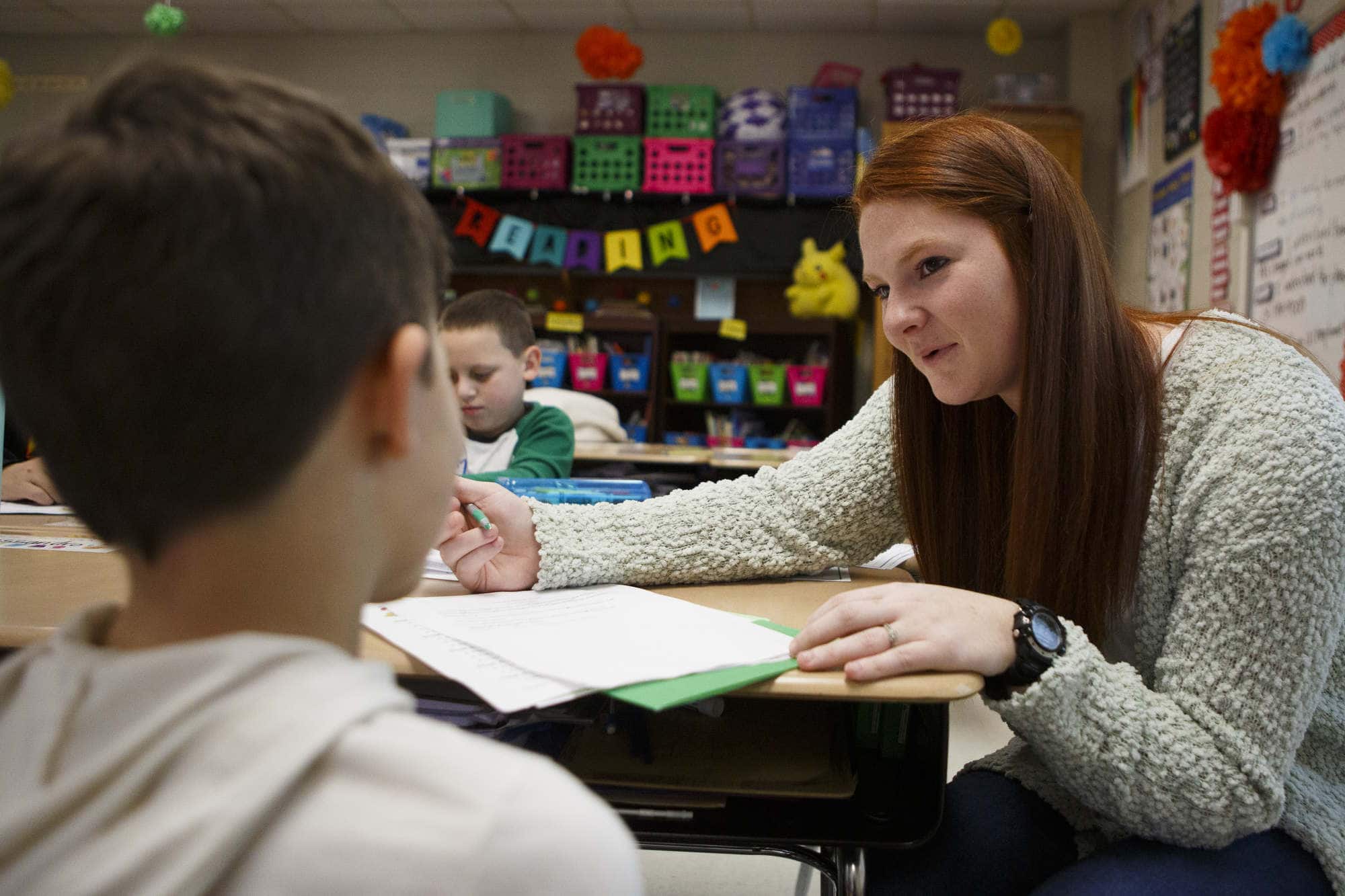 An education student teaches a child in a classroom