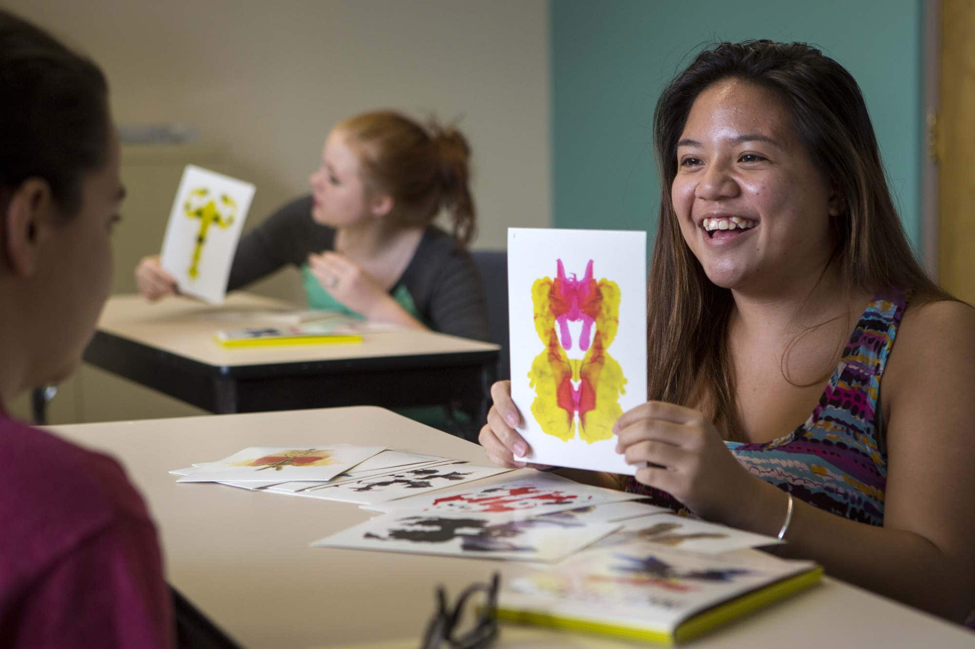 A student holds up an ink blot test during a psychology activity