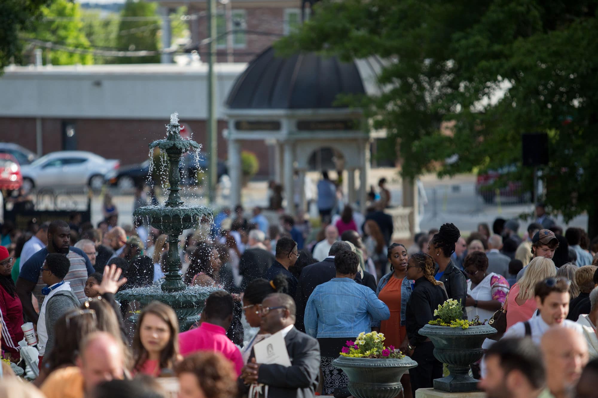 A crowd of family and friends wait on Brenau's front lawn for graduates