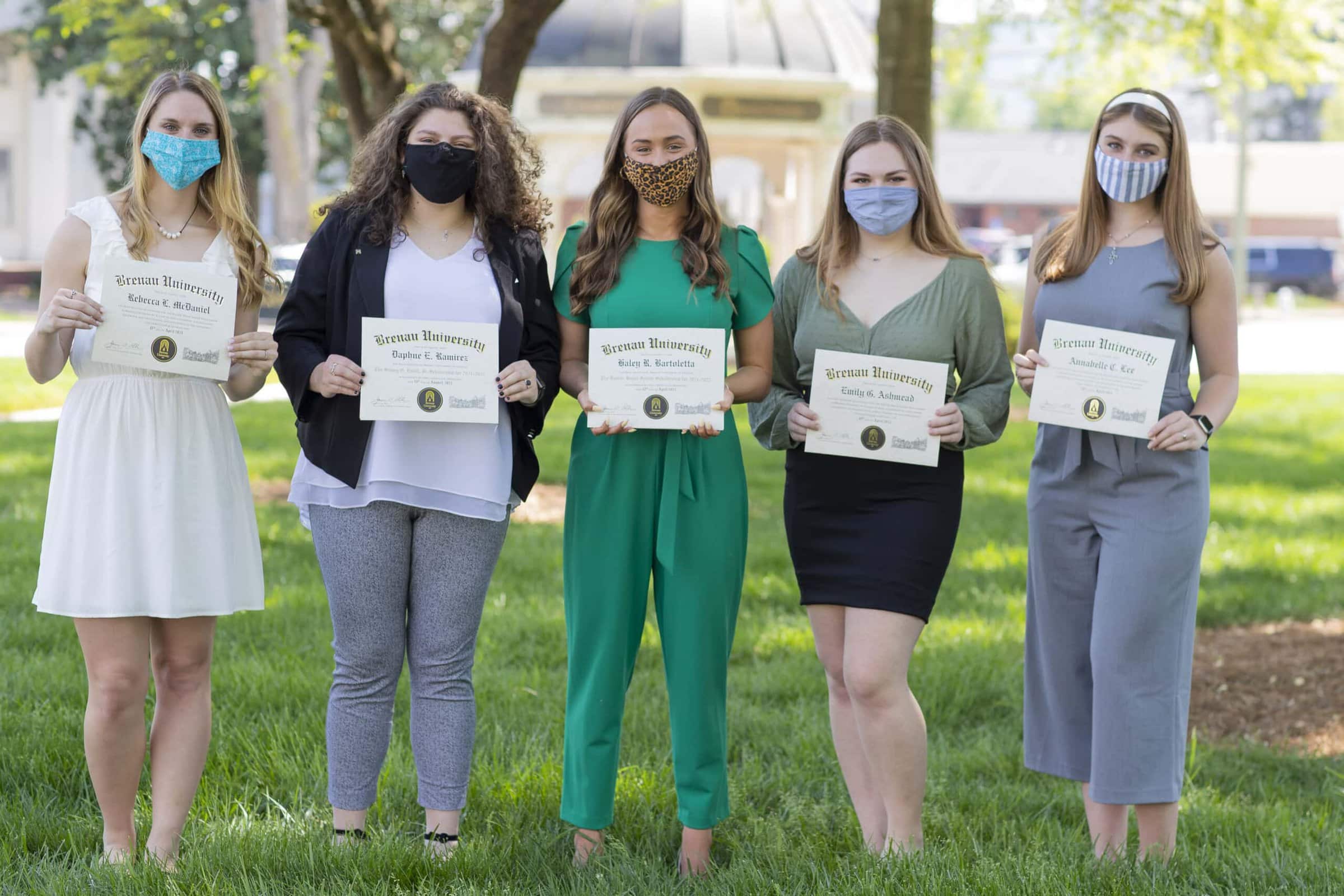 The Baxter-Bryan Scholarship finalists outside in masks hold their certificates.