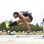 An athlete landing in the long jump.