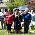 family stands and salutes during pledge of allegiance