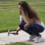 A student prepares to hit a plate with a hammer.