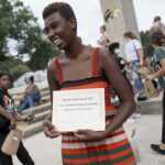 A student holds up an award.