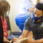 A student in Brenau's OT program helps out at the Caregiver Assistance and Resource Event (CARE) Fair.