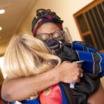 Sheena Weghorn embraces a fellow faculty member after the convocation