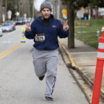 A runner in the 2022 Dempsey Dash holds up peace signs