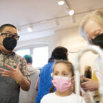 Huy Chu helps a Brownie Girl Scout during the pottery event