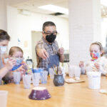 Huy Chu shows the Brownies how to paint their bowls