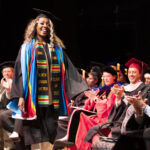 Keren Kapwadi walks across the stage at The Women's College graduation ceremony