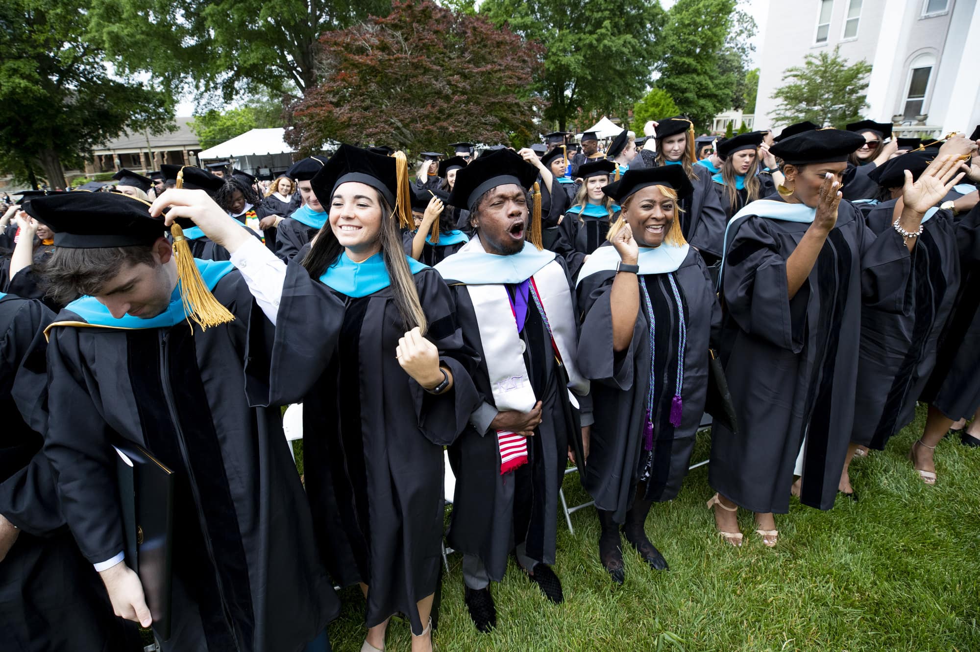 Doctoral students cheer as they turn their tassels