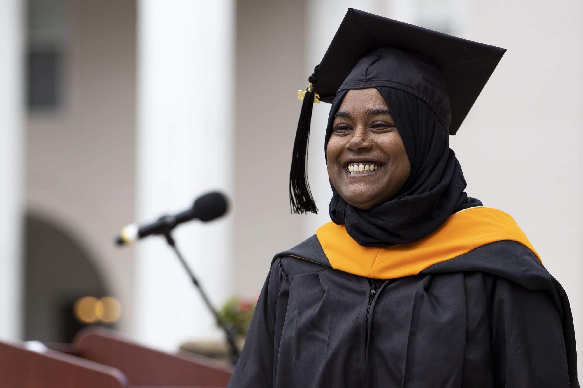 A graduate student from an online program crosses the stage at commencement