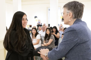 Shakhenyah Beersheba Reyes-Fernandez shakes President Anne Skleder's hand