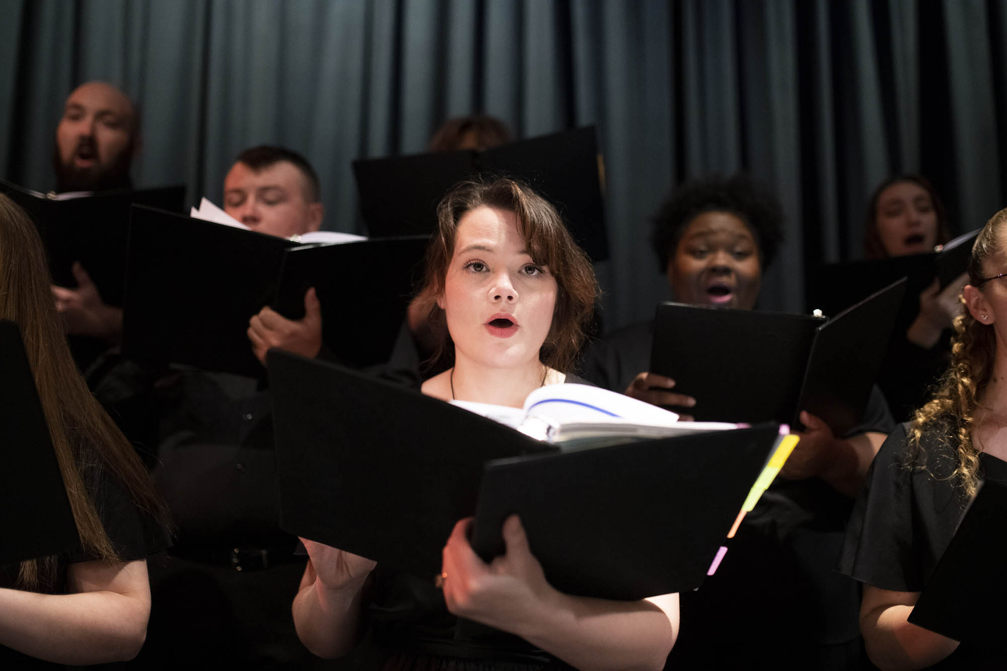 Students sing while holding music