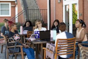 Students gathered around a table on the patio of the Tea Room