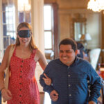 A blindfolded woman is escorted to her seat at the Dining in the Dark event.