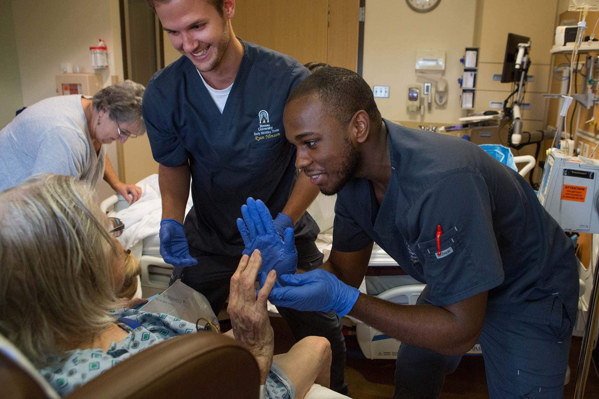 Two student physical therapists work with a patient