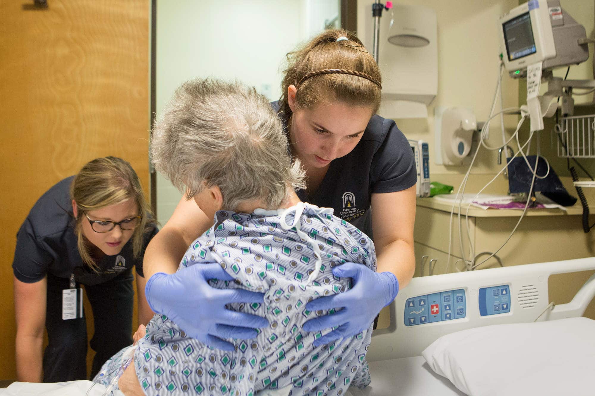 Physical therapy students work with a patient in the hospital