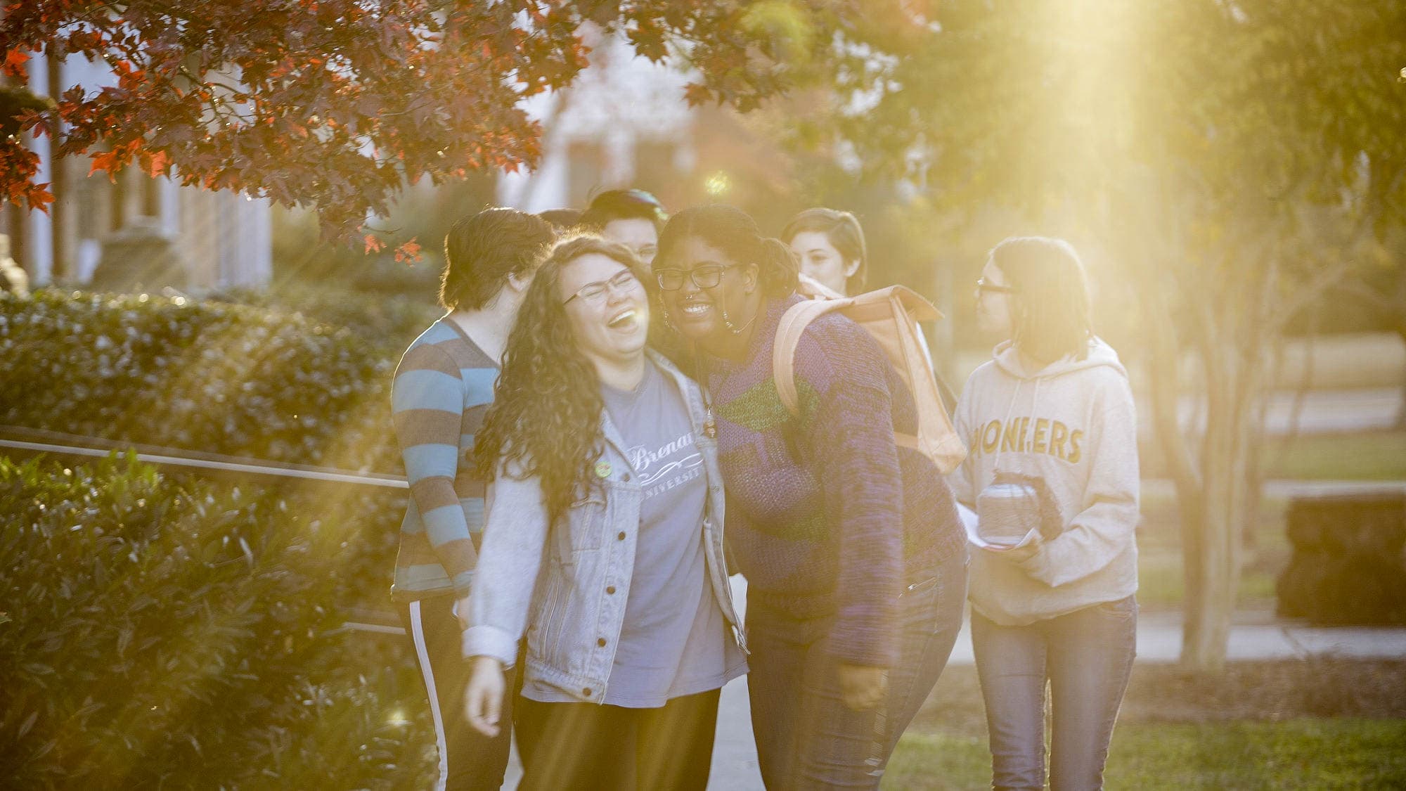 Women's College students laugh while walking on campus