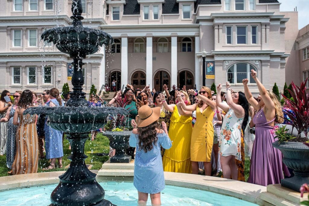 A group of students stands in front of the fountain.