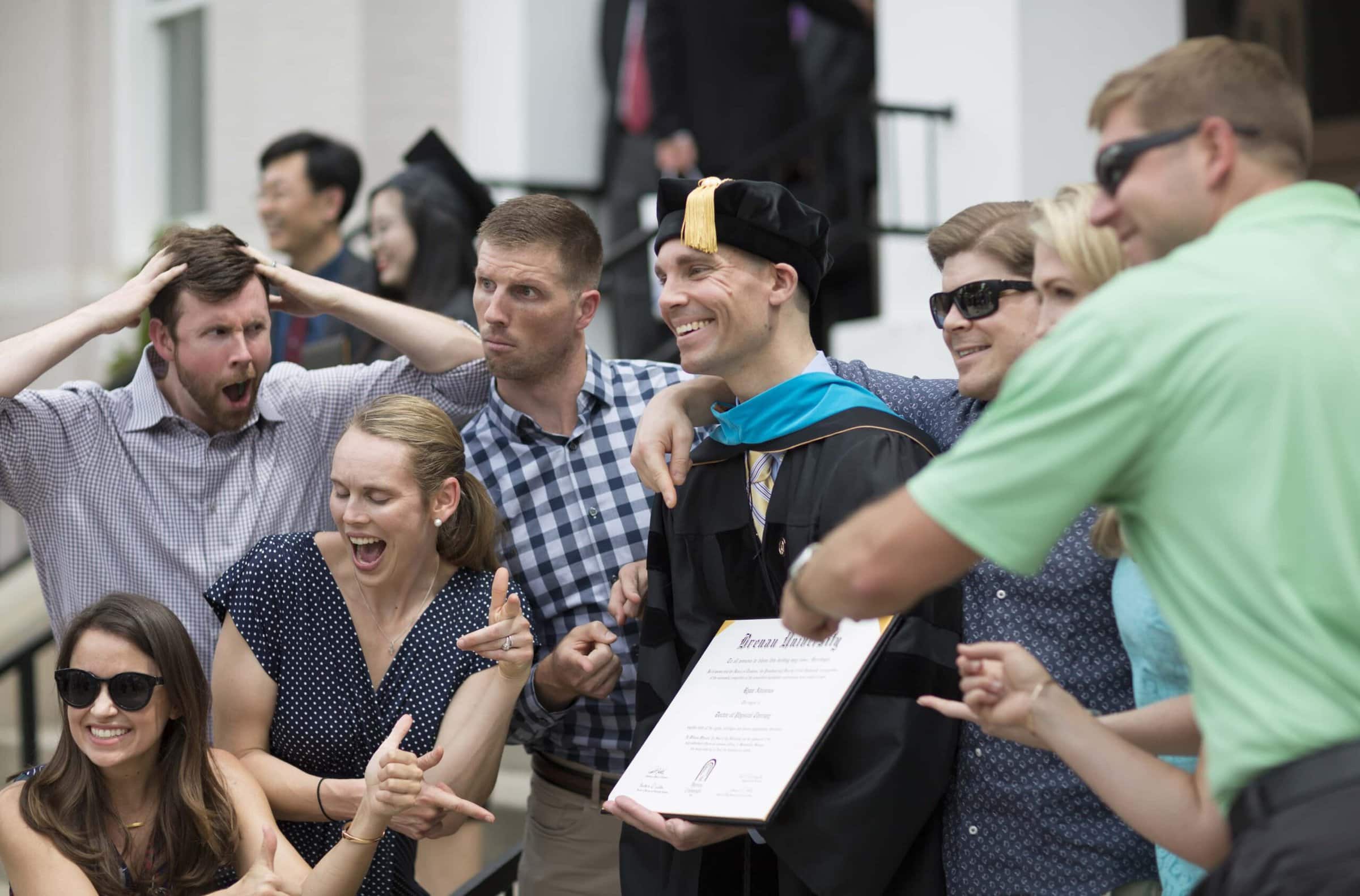 Ryan Ahlenius (center), one of the first graduates from Brenau University with a Doctor of Physical Therapy, jokes with friends following the 2018 Spring Commencement Ceremony on Saturday, May 5, on Brenau University's historic Gainesville campus. (Nick Bowman for Brenau University)