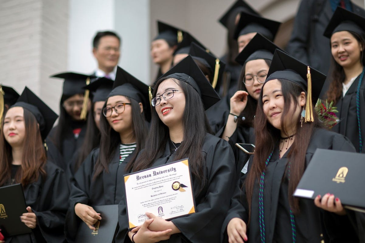 Members of the first cohort of the 2+2 partnership between Anhui Normal University and Brenau University smile with their diplomas following the 2018 Spring Commencement Ceremony on Saturday, May 5, on Brenau University's historic Gainesville campus. (Nick Bowman for Brenau University)
