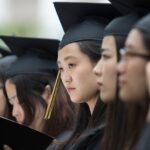 Xin Yan Qiu (center) looks up from her diploma during the 2018 Spring Commencement Ceremony on Saturday, May 5, on Brenau University's historic Gainesville campus. (Nick Bowman for Brenau University)