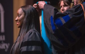 Clinical Doctorate in Physical Therapy Candidate Andrew Thuc Phan is hooded during the Brenau University College of Health and Sciences Graduate Hooding ceremony at Pearce Auditorium.