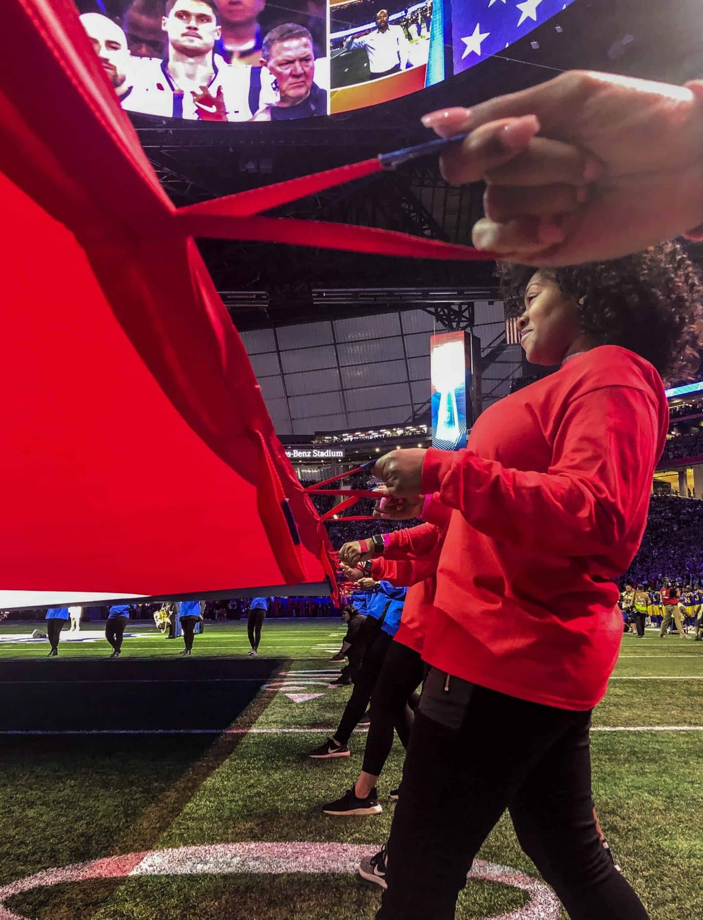 Brenau University student-athletes from the competitive cheer and dance teams hold the American flag during the pregame festivities at Super Bowl LIII on Sunday, Feb. 3, in Mercedes-Benz Stadium.