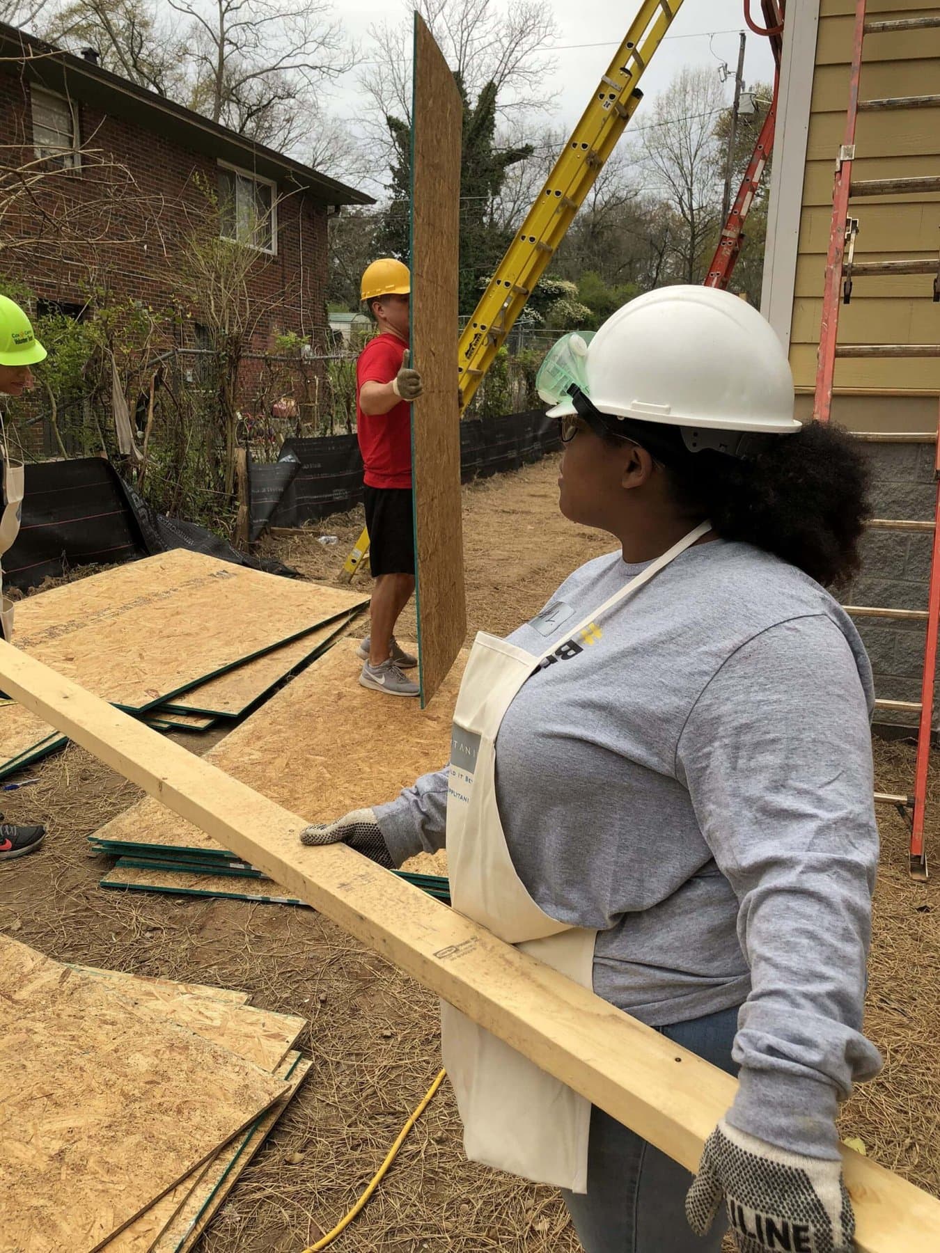 Student moving boards on the construction site .