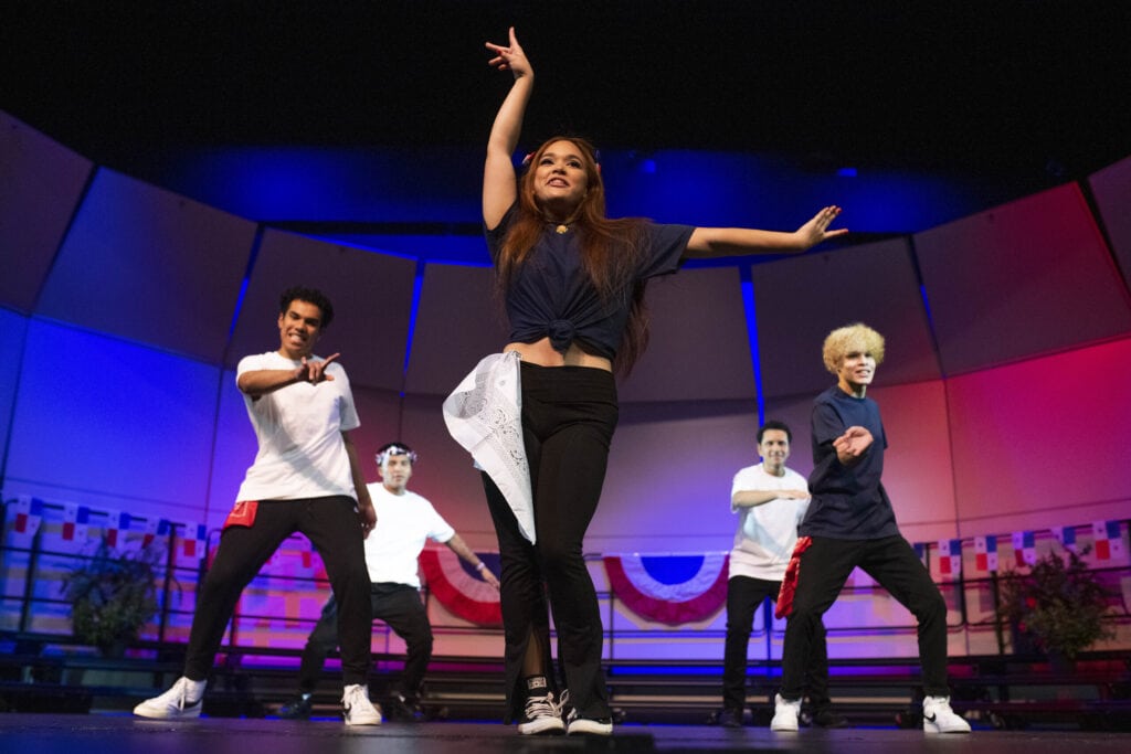 A female student poses with flair as her fellow students dance back up for Panamanian Cultural day.