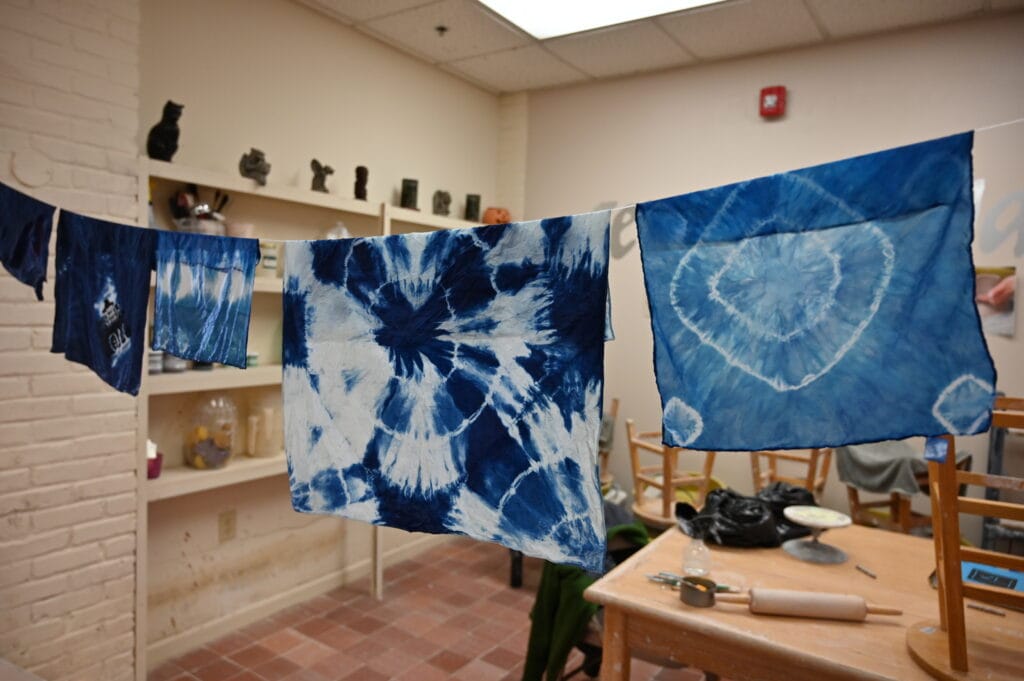 Indigo-dyed fabric pinned on a line to dry during International Week.