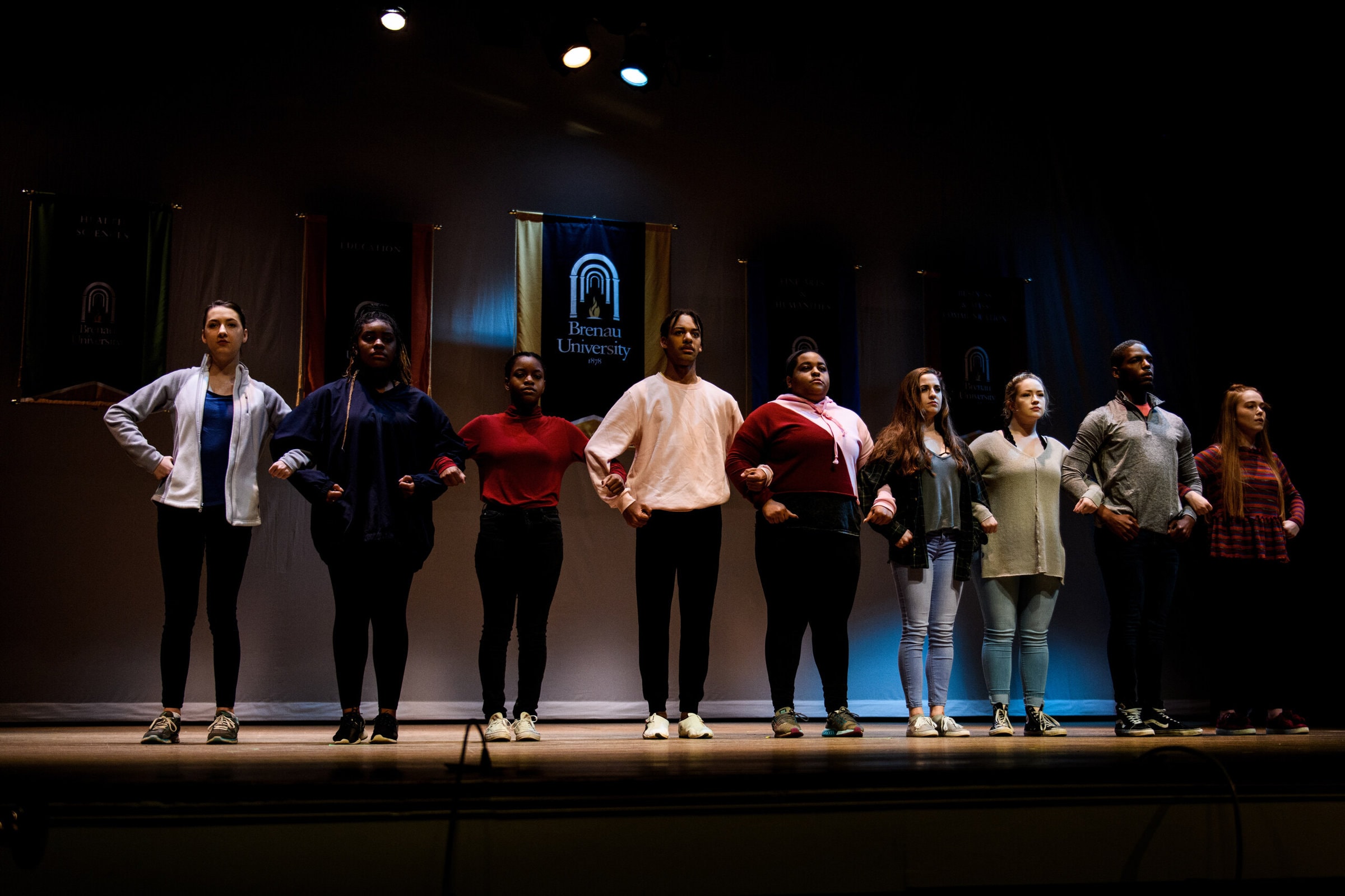 Students link arms together on stage at MLK Convocation 2019.