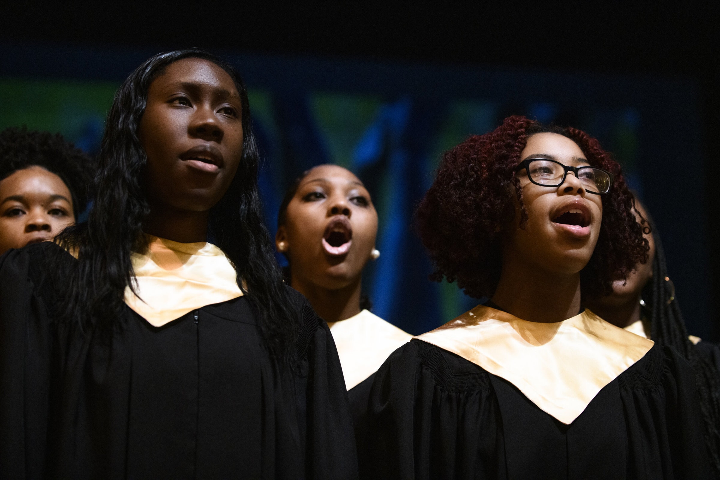 women wearing choir robes sing