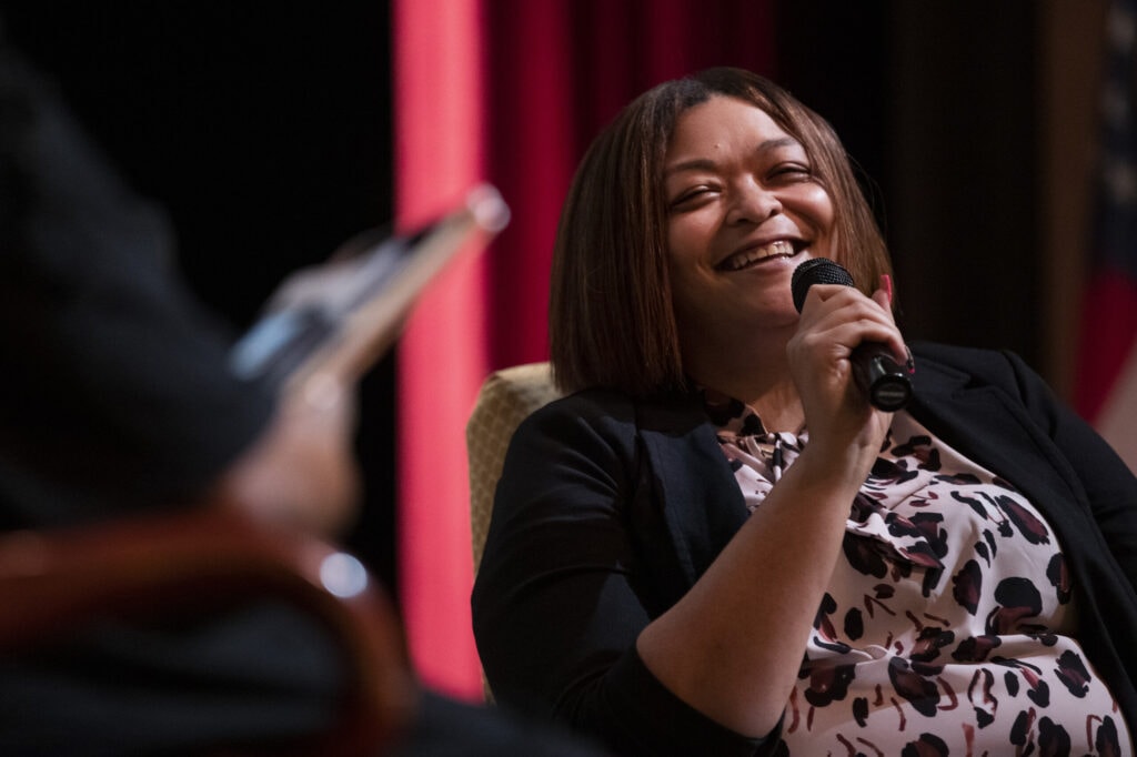 A woman holding a microphone smiles