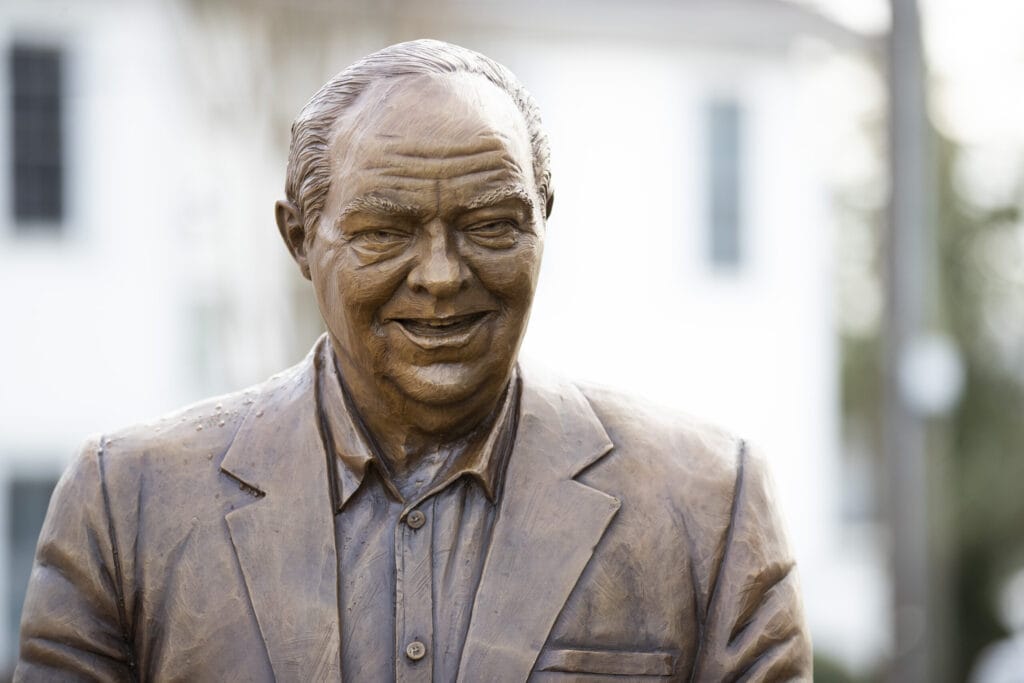 Close up shows the smiling face of bronze statue of Jim Walters