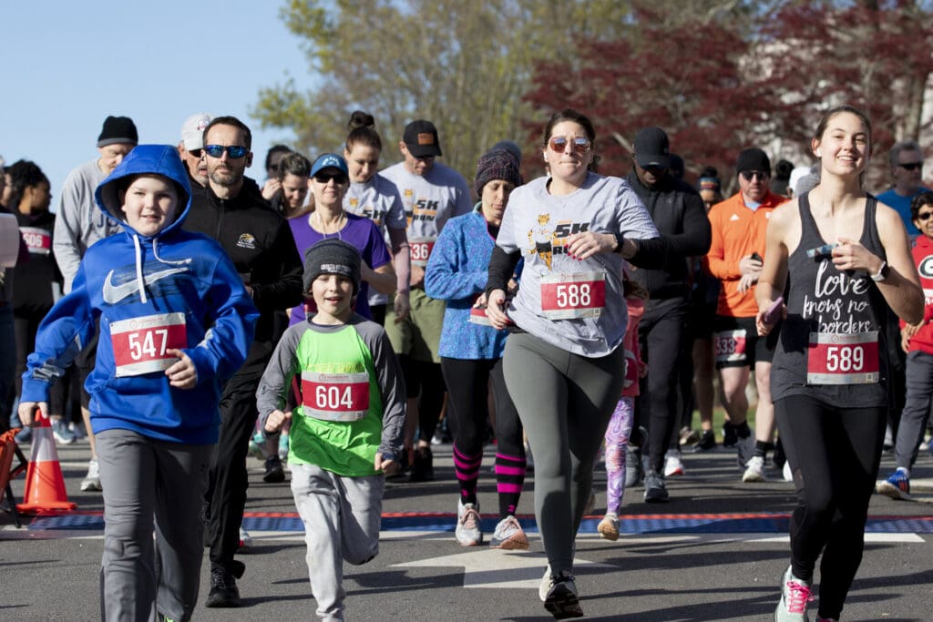 A group of runners take off from the starting line.