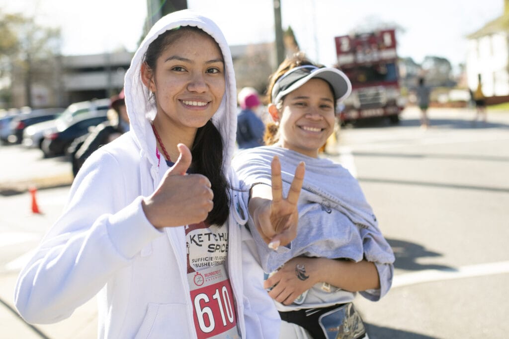 Two female student pose for a photo at the race.