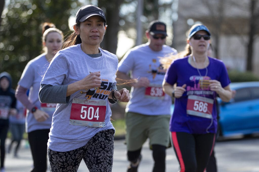 A female runner leads a group during the Dempsey Dash