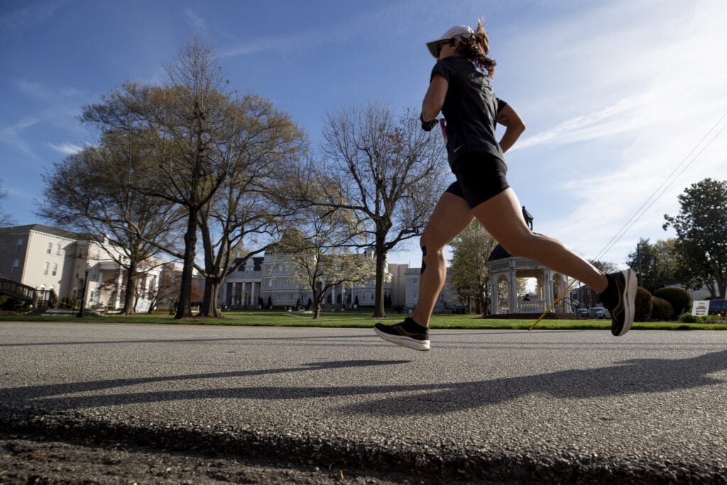 A female runner dashes past front campus.